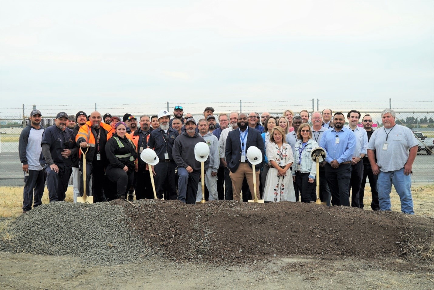 Facilities team and Senior Staff smile for photo at groundbreaking location.