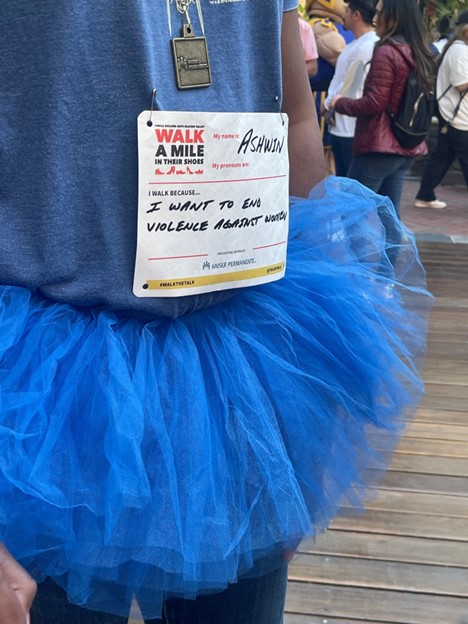 An employee's name tag says they walk because they want to end violence against women.